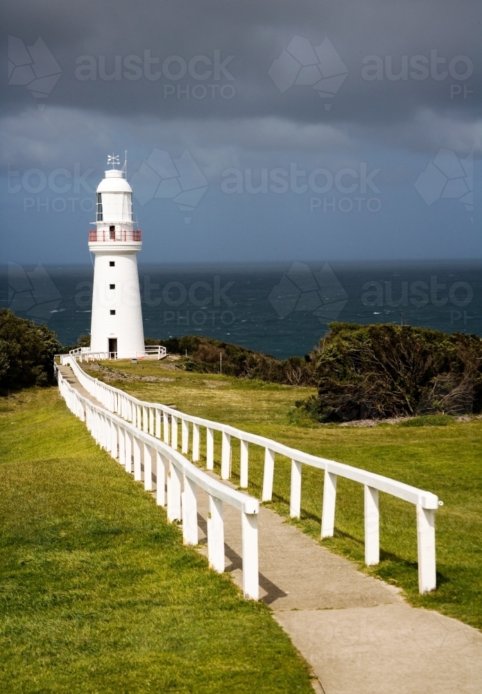 Path leading to lighthouse on cape - Australian Stock Image