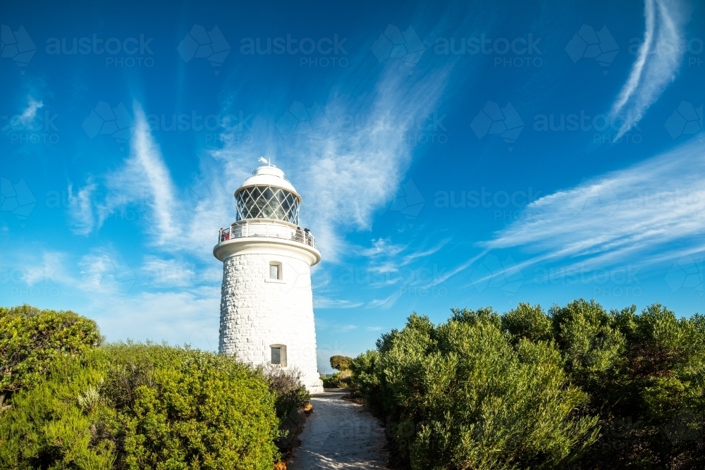 Pathway leading up to lighthouse on a windy blue sky day. - Australian Stock Image