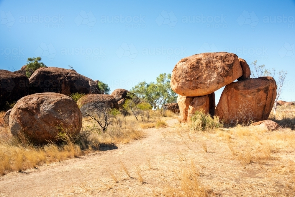 Pathway to large rock formations that are sitting on top of each other. - Australian Stock Image