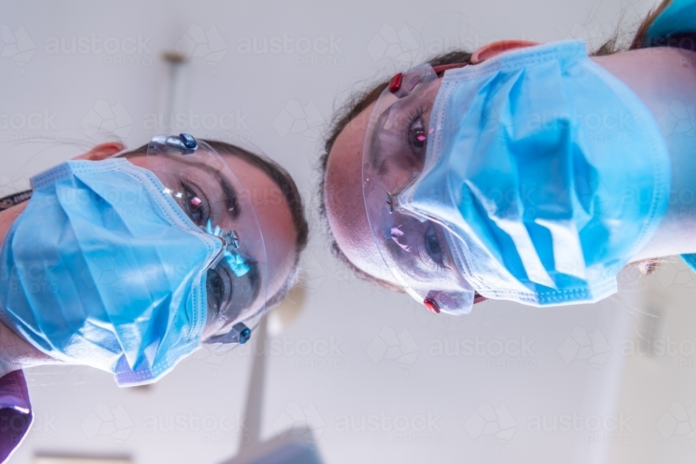 Patient view of dentist and dental assistant - Australian Stock Image