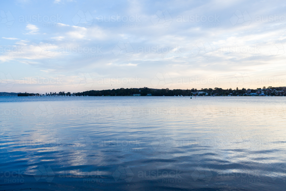 peaceful pastel scene of rippling water of cockle bay from speers point park in dusk light - Australian Stock Image