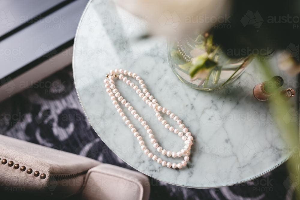 Pearl necklace on marble coffee table - Australian Stock Image