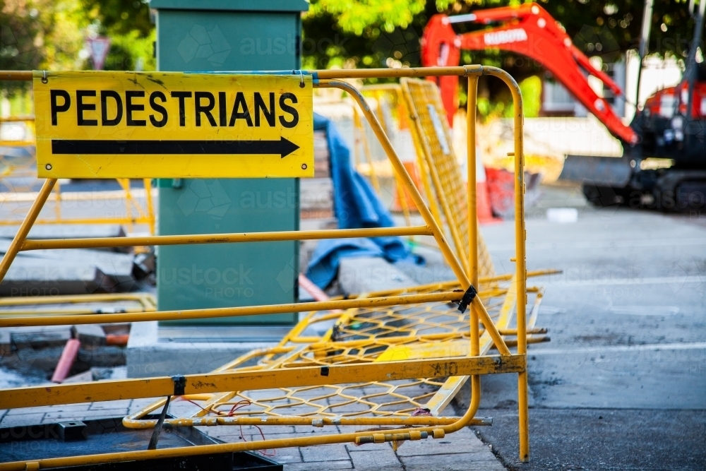 Pedestrians this way sign with barrier fence at worksite - Australian Stock Image