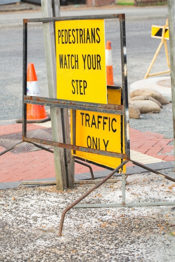 "Pedestrians watch your step" sign on roadside - Australian Stock Image