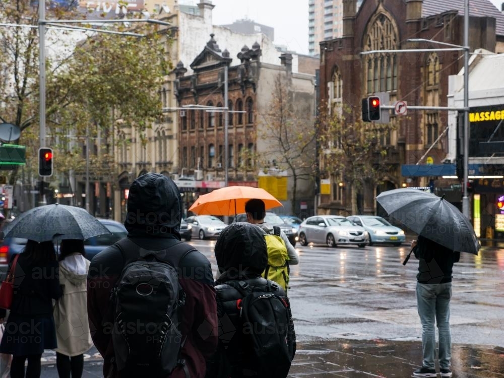 Pedestrians with umbrellas on a wet and cold Sydney day - Australian Stock Image