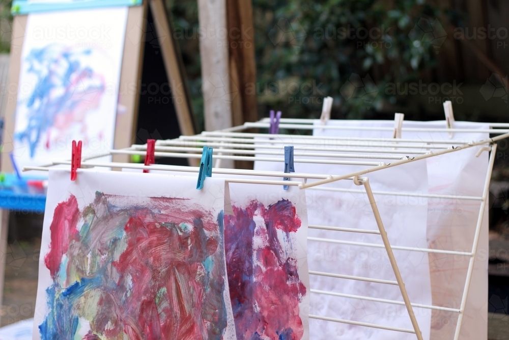 Pegged artwork drying on clothes rack - Australian Stock Image