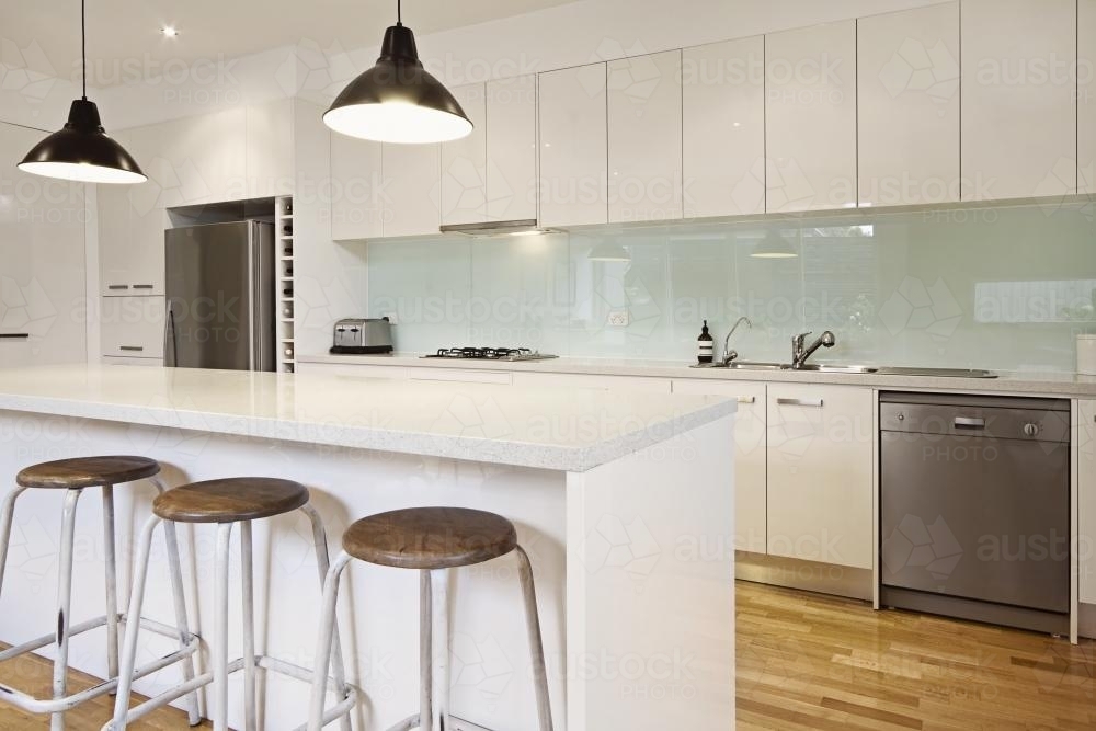 Pendant lighting and bar stools in modern townhouse - Australian Stock Image