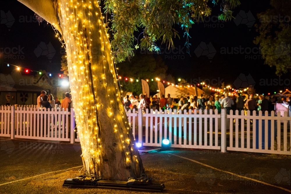 Fairy lights and people at a party at night - Australian Stock Image
