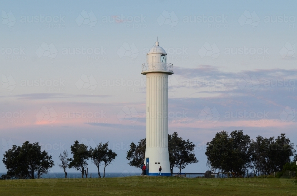 People at the base of Yamba Lighthouse at dusk - Australian Stock Image