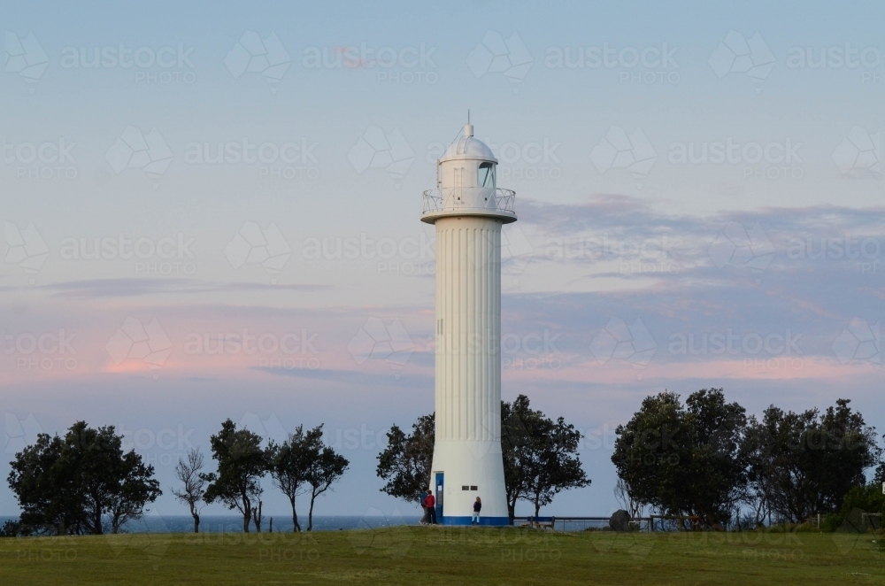 People at the base of Yamba Lighthouse at dusk - Australian Stock Image