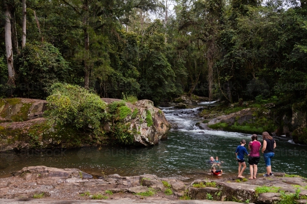 People at the edge of a swimming hole in creek at ladies well - Australian Stock Image