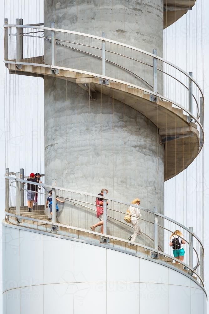 People climbing down the spiral staircase of a lookout tower. - Australian Stock Image