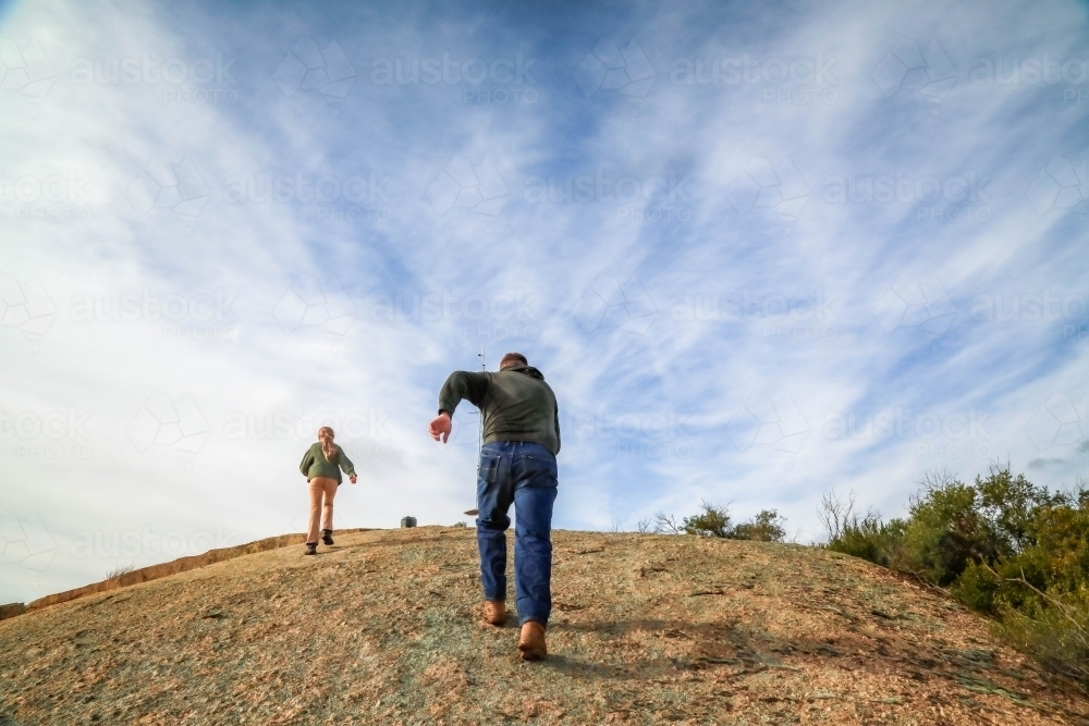 People climbing to the summit of Mitiamo Rock kin Victoria - Australian Stock Image