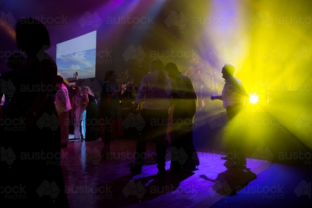 People dancing on a dance floor with bright lights - Australian Stock Image