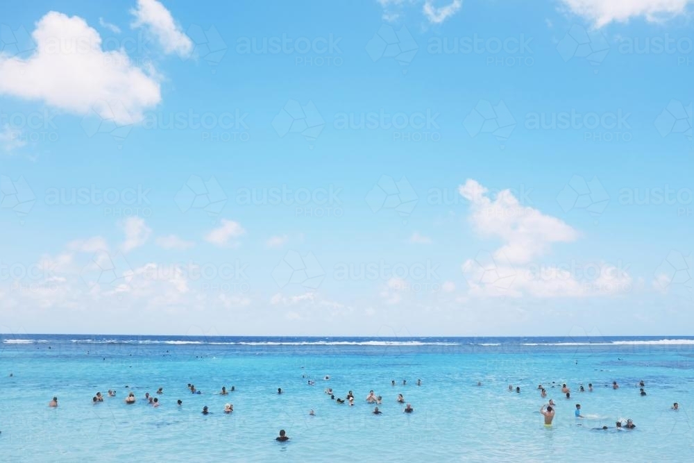 People enjoying calm blue water at the beach - Australian Stock Image