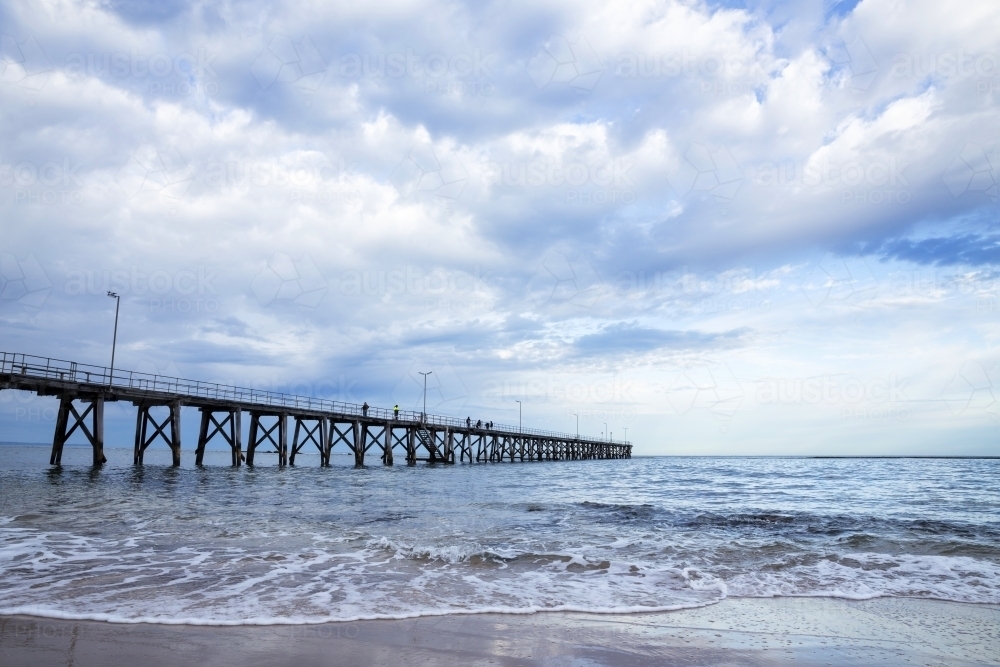 People fishing from jetty on a stormy day - Australian Stock Image
