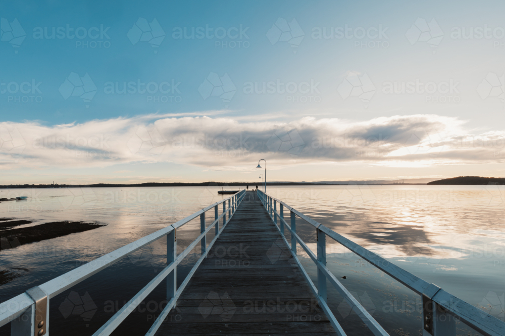 People fishing in Lake Macquarie off end of jetty at Murrays Beach - Australian Stock Image