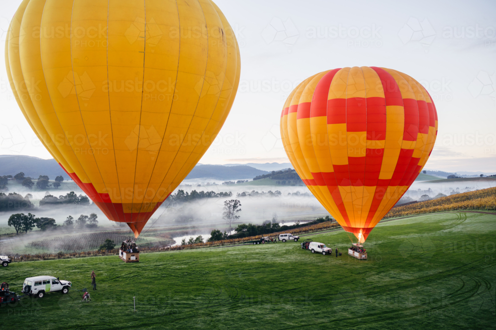 People Hot Air Ballooning on cold misty morning taking off - Australian Stock Image