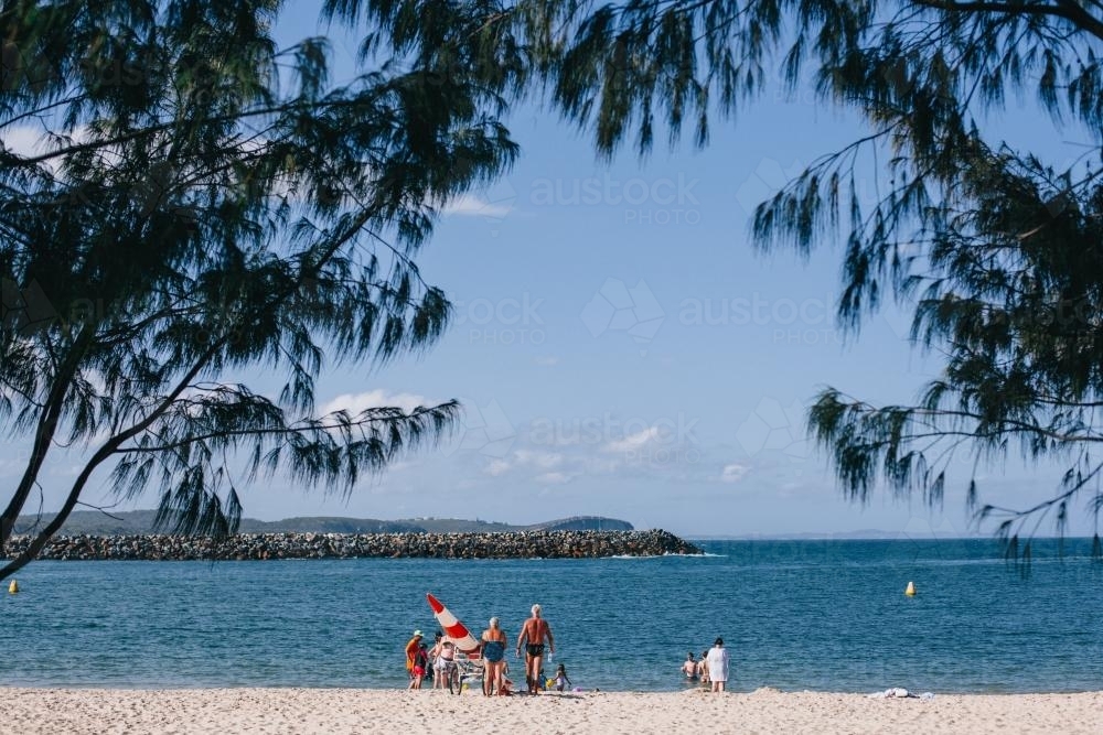 People in distance enjoying a sunny day at the bay - Australian Stock Image