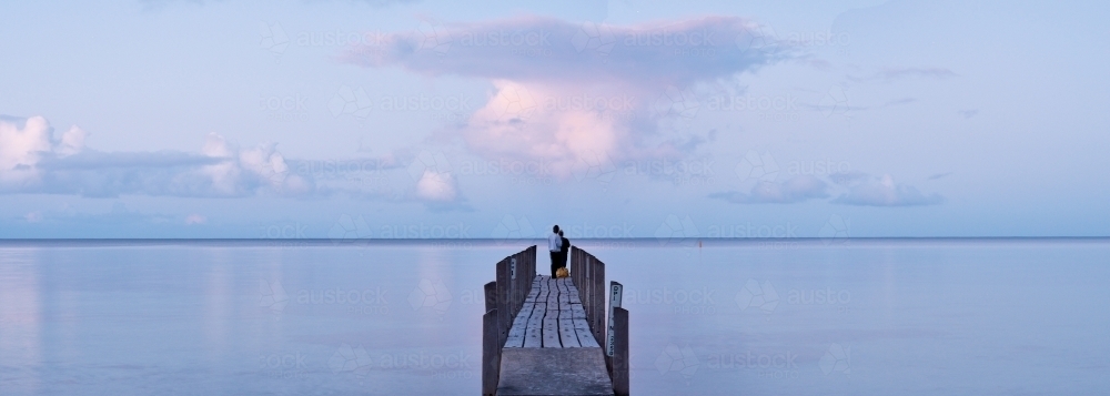 People On A Small Jetty In The Dusk Light - Australian Stock Image