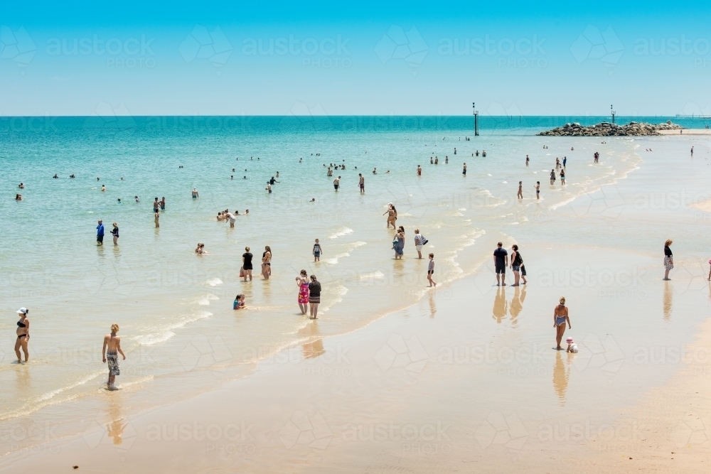 People on the sand and in the water at the beach - Australian Stock Image