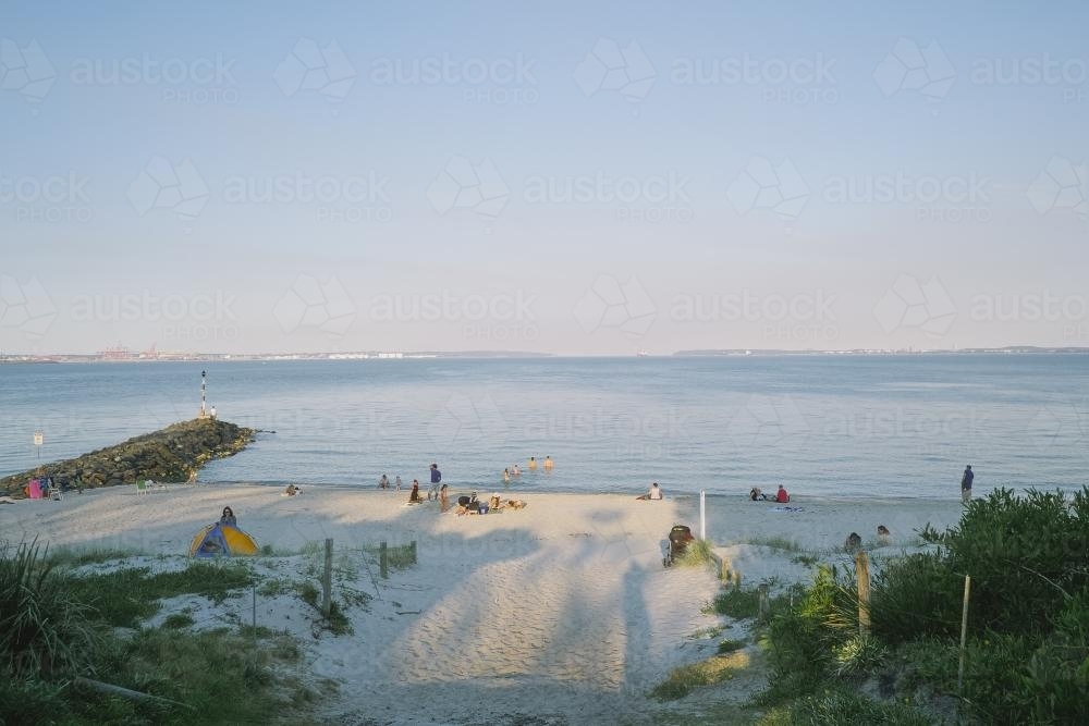 People relaxing on the beach on a summer evening - Australian Stock Image