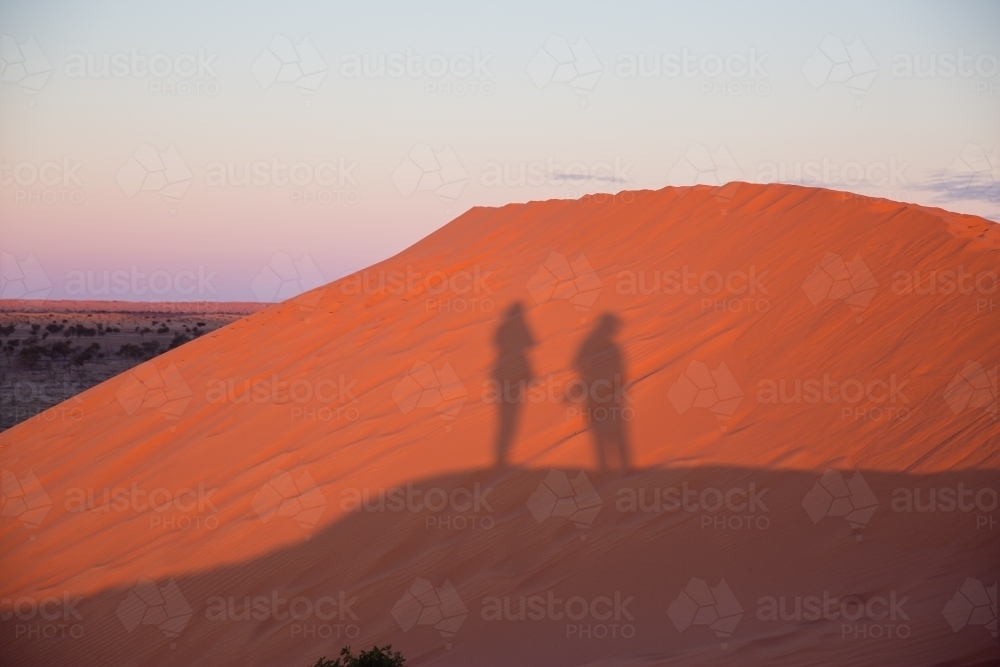 People shadows on red sand dune - Australian Stock Image