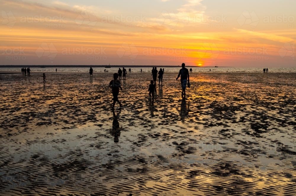 People silhouetted in a colourful sunset - Australian Stock Image