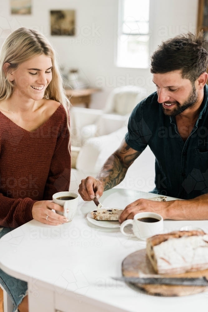 People sitting at a table drinking coffee and eating artisan bread - Australian Stock Image