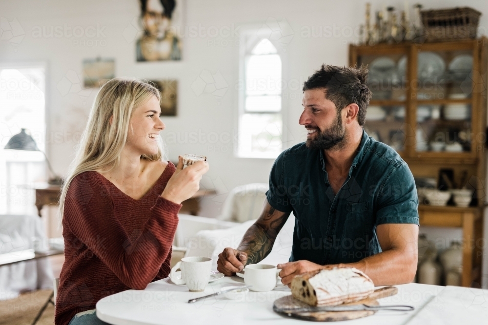 People sitting at a table drinking coffee and eating artisan bread - Australian Stock Image