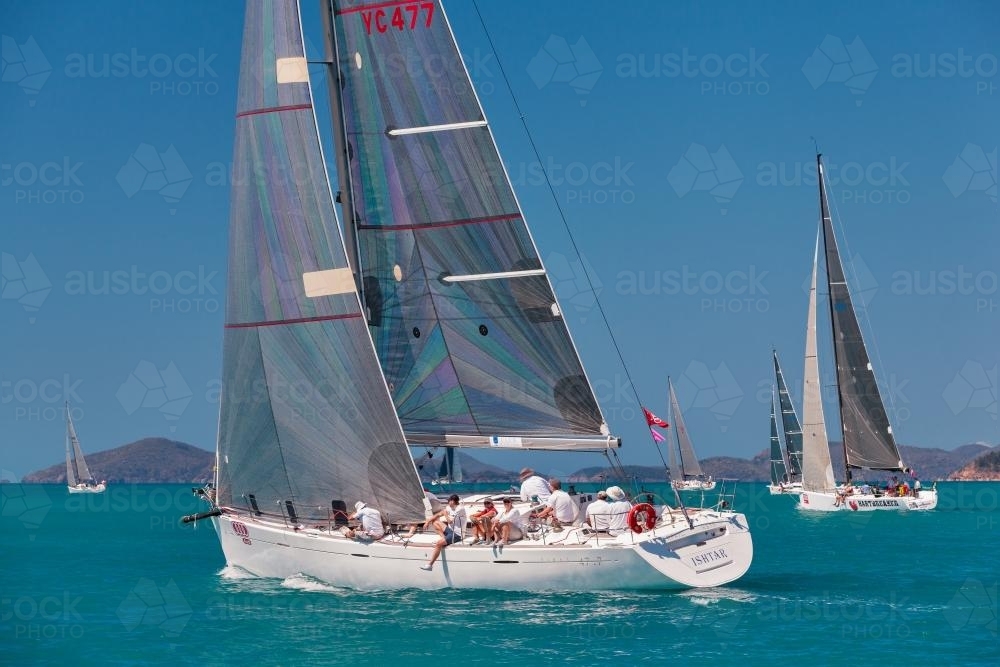 People sitting on a racing yacht at Hamilton Island Race Week - Australian Stock Image