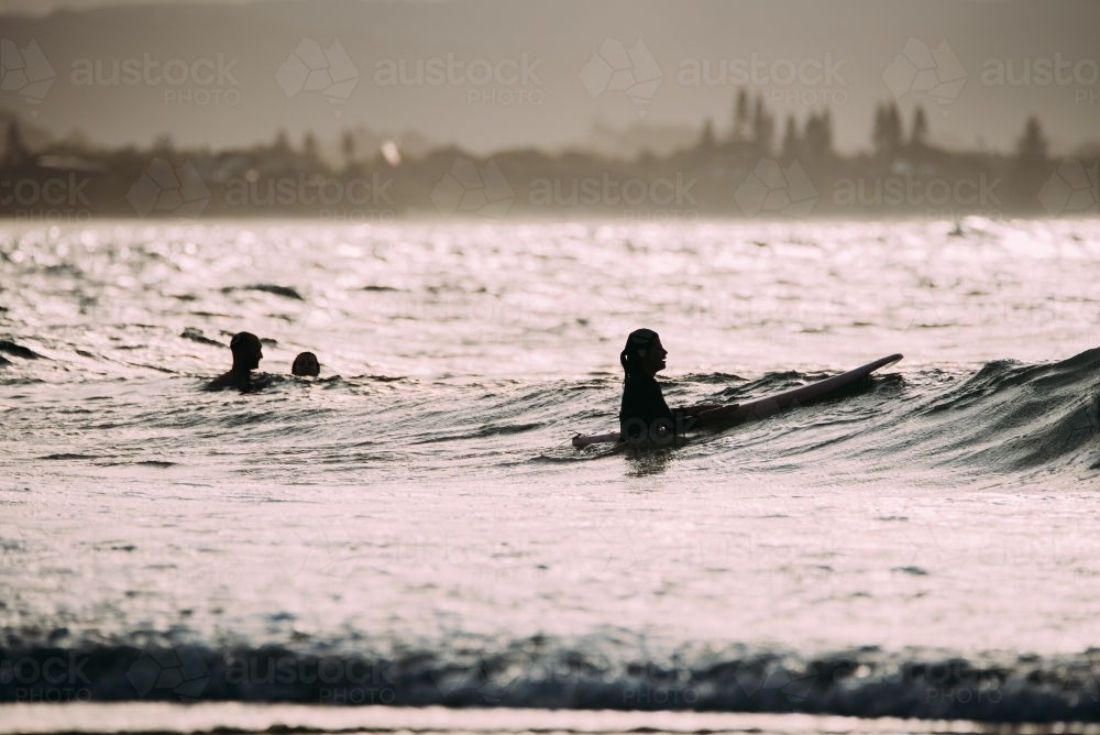 People surfing at sunset - Australian Stock Image