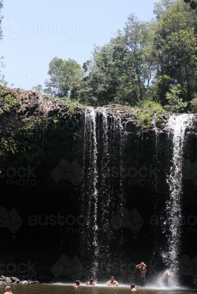 People swimming at the base of a waterfall - Australian Stock Image