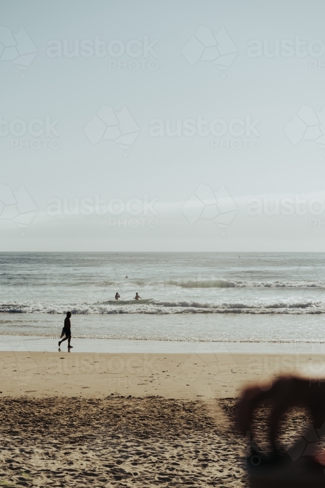 People swimming at Yamba Beach in morning light - Australian Stock Image