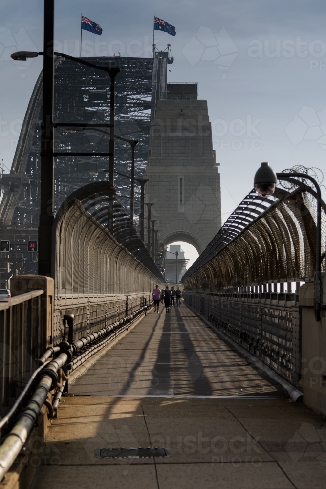 People walking across Sydney Harbour Bridge on walkway - Australian Stock Image