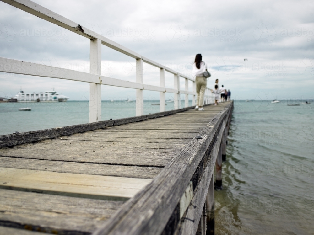 People walking along a jetty in a coastal location - Australian Stock Image
