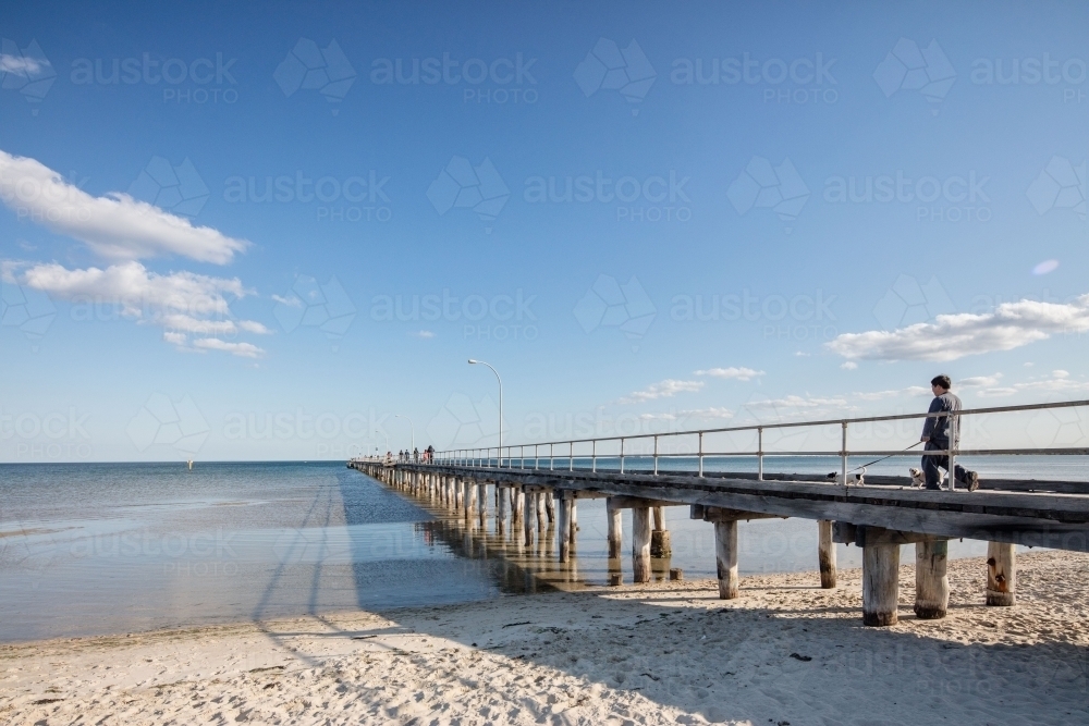 People walking along a jetty on the beach - Australian Stock Image