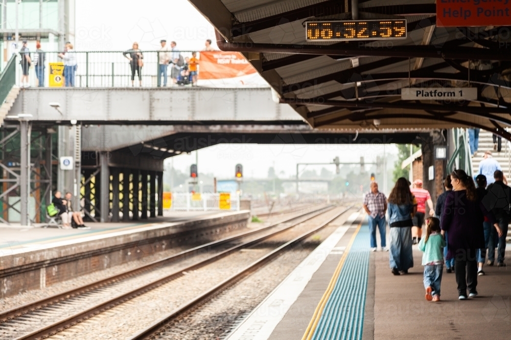 People walking away on platform at train station - Australian Stock Image
