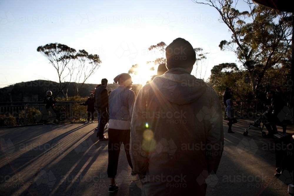 People walking into afternoon sunlight - Australian Stock Image