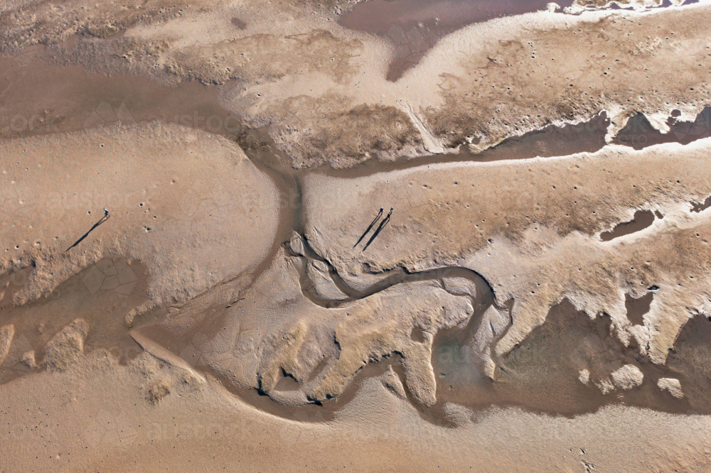 People walking on the mud flats on lily's beach near Tannum sands - Australian Stock Image