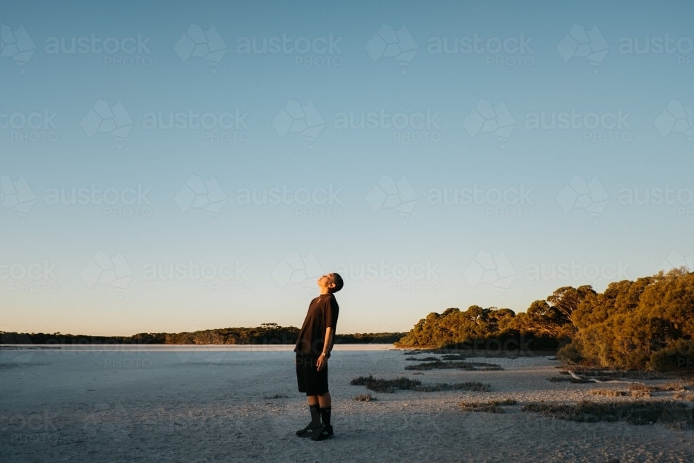 Person basking in sunset light - Australian Stock Image