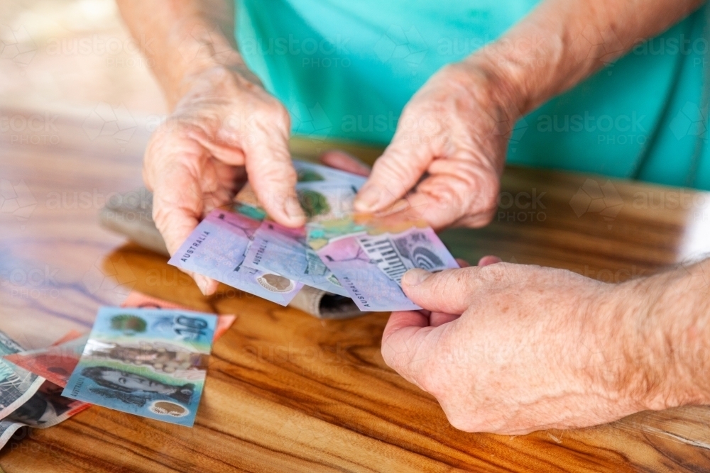 Person handing over money in australian bank notes - Australian Stock Image