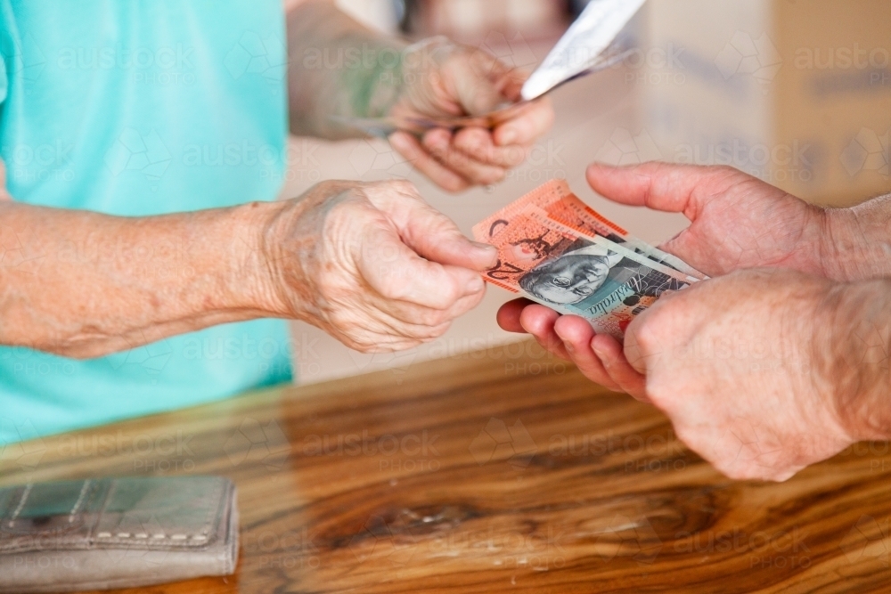 Person handing over money in australian bank notes - Australian Stock Image