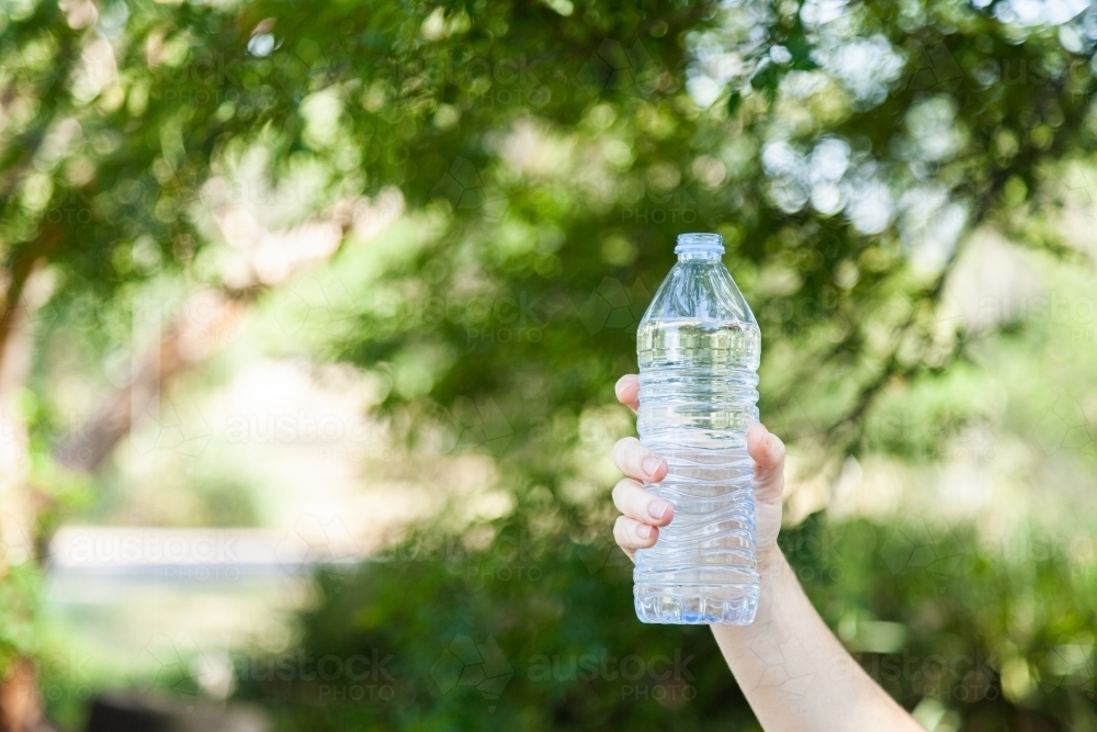 Person holding up plastic water bottle - Australian Stock Image