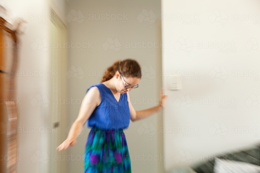 Image of Person leaning on doorframe experiencing vertigo, spinning
