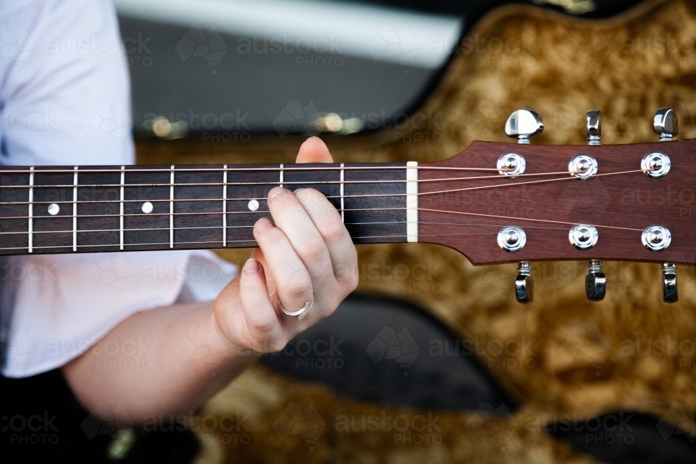 Person playing chords on a guitar - Australian Stock Image