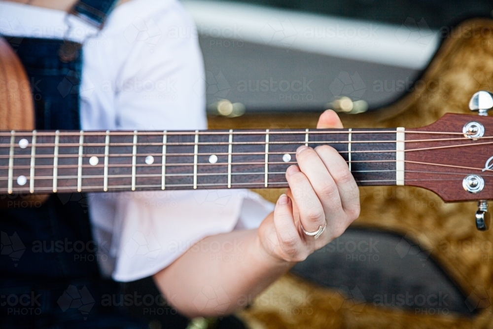 Person playing chords on a guitar - Australian Stock Image