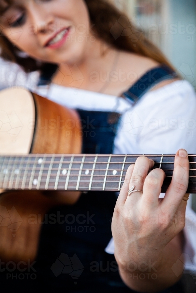 Person playing chords on a guitar - Australian Stock Image