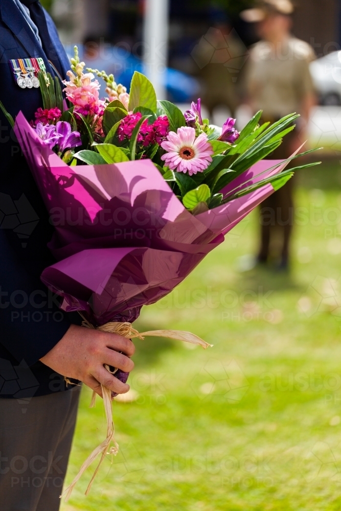 Person presenting flowers to lay on remembrance day - Australian Stock Image