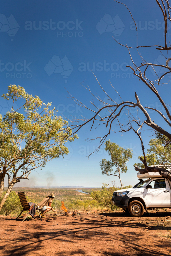 person relaxing in chair camping in Australian outback - Australian Stock Image